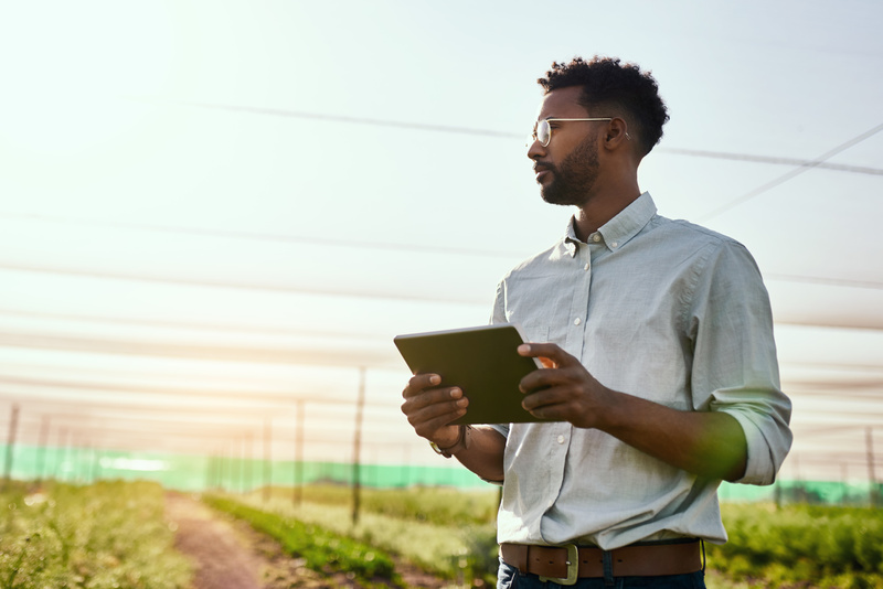 farmer thinking with digital tablet in hand