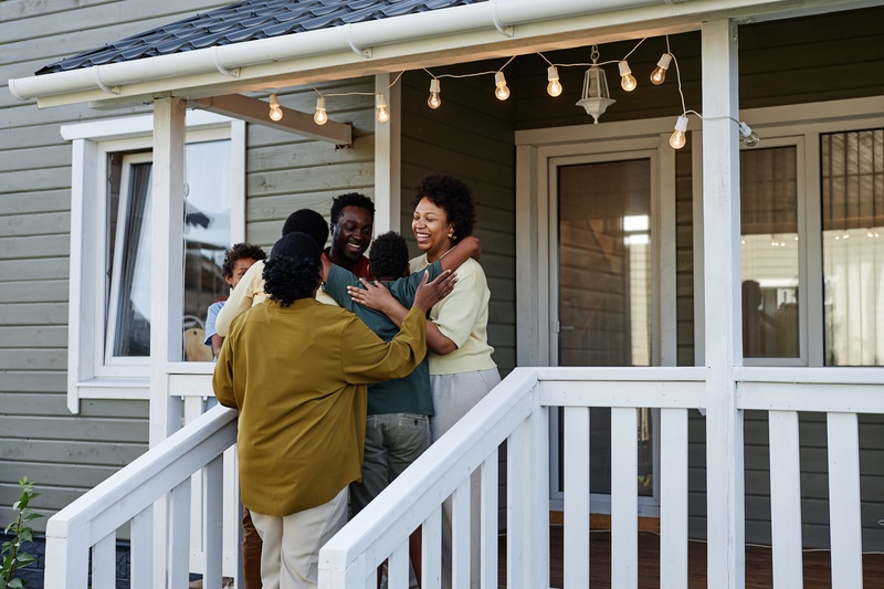 happy black family embracing on porch of new home